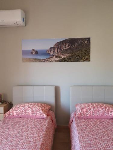 two beds in a room with a picture on the wall at B&b Paolo e Daniela in Carbonia