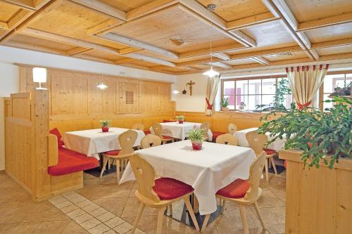 a dining room with two tables and chairs in a room at Hotel Ortler in Ultimo