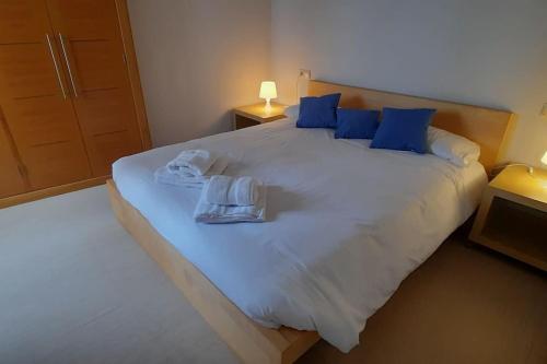 1 dormitorio con 1 cama blanca grande con almohadas azules en Luz de Vigo, en Vigo
