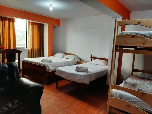 Hostal Don Cristobal في اياكوتشو: غرفة بسريرين بطابقين وأريكة