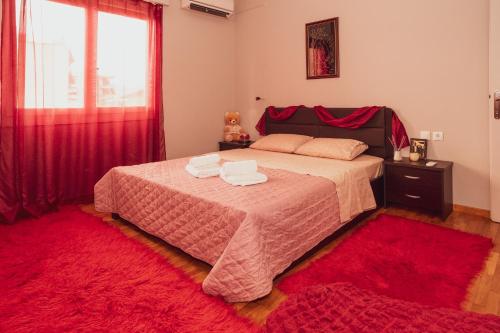 a bedroom with a bed with a red rug at Alexandra's Apartment in Volos