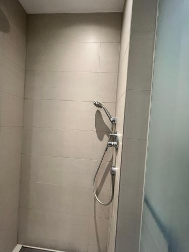 um chuveiro numa casa de banho com uma porta de vidro em sharing studio apartment with me em Munique