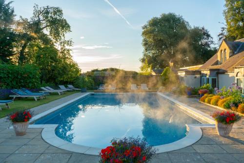 a swimming pool with a fountain in a yard at Beechfield House in Beanacre