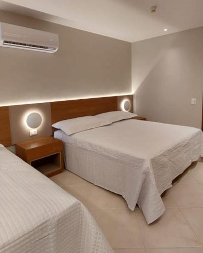 a hotel room with two beds and a fan at Sol Victoria Marina in Salvador