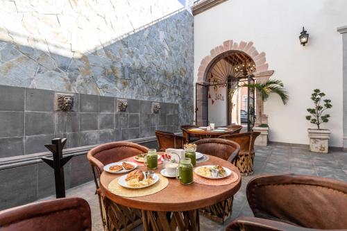 a restaurant with tables and chairs in a room at Hotel Meson de Sara in Quer&eacute;taro