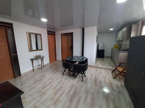 ein Wohnzimmer mit einem Tisch und Stühlen sowie eine Küche in der Unterkunft Acogedora casa cerca al centro in Manizales