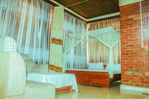 een slaapkamer met een hemelbed en ramen bij Heartland hotel in Kigali