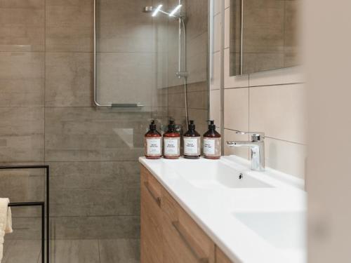 a bathroom with three bottles of alcohol on a sink at Apartment The City in Ghent
