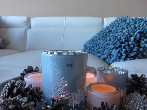 a table with candles and pine cones on a couch at Zonnestraal 0302 in Nieuwpoort