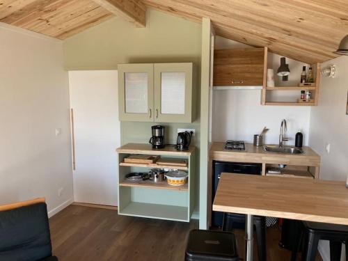 - une petite cuisine avec un comptoir et une table dans l'établissement l'Observatoire de l'Aérogrange, à Biscarrosse