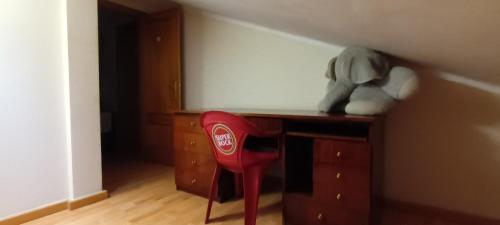 a red chair sitting in front of a wooden desk at Global Guest in Sintra