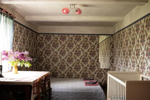a room with a bed and a table with flowers at Coastal Home Muini Ūši in Kolka