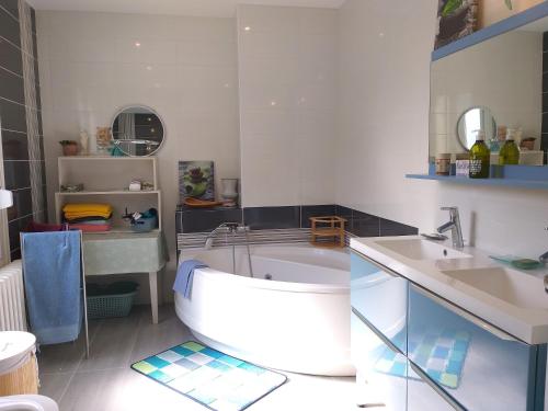 a bathroom with a tub and a sink at Magnifique maison familiale située à MORLAIX in Morlaix