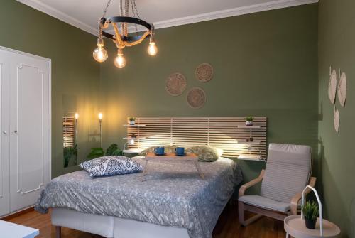 アテネにあるAcropolis Apartment with a unique viewの緑のベッドルーム(ベッド1台、椅子付)