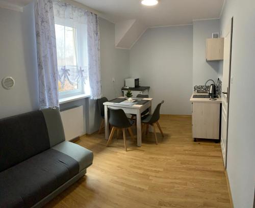 a living room with a couch and a table with chairs at Pokoje gościnne Pod Lwami in Kudowa-Zdrój