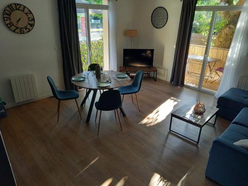 - un salon avec une table, des chaises et une télévision dans l'établissement VILLA DEGANNE T2 Plein sud, à Arcachon