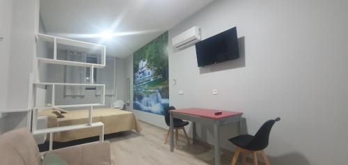 a living room with a small table and a bedroom at Apartamentos Las trece llaves Jacuzzi bajo reserva in Merida