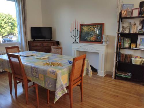 a dining room with a table with chairs and a fireplace at Magnifique maison familiale située à MORLAIX in Morlaix