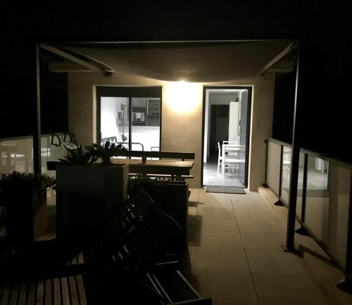 une chambre avec une table et un banc dans l'obscurité dans l'établissement Toit terrasse les Embiez, à Six-Fours-les-Plages