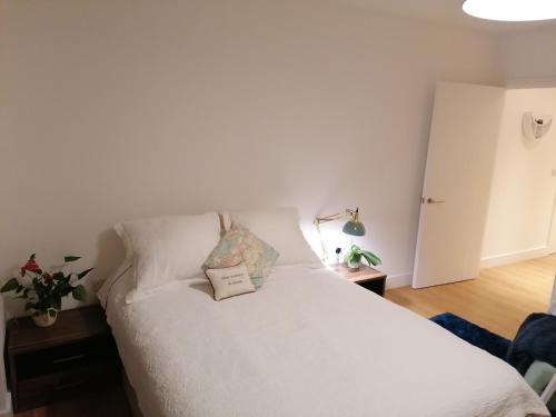 a bedroom with a white bed with a book on it at Entire Flat - Modern Flat near Canary Wharf in London