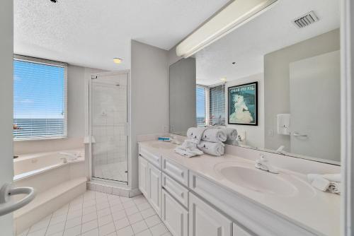 a white bathroom with a tub and a sink at Beach Colony Tower 12B in Perdido Key
