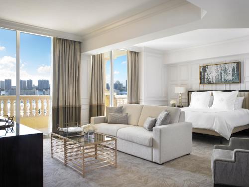 um quarto de hotel com uma cama, um sofá e uma mesa em Acqualina Resort and Residences em Miami Beach