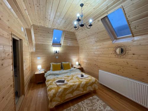 - une chambre avec un lit dans une pièce dotée de murs en bois dans l'établissement Casa Tudor, à Padis