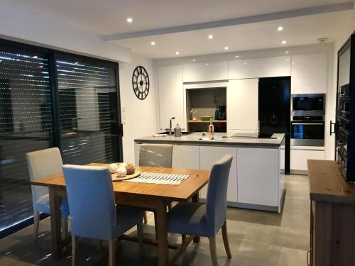 une cuisine et une salle à manger avec une table et des chaises en bois dans l'établissement Villa Lou Gaou, à Six-Fours-les-Plages