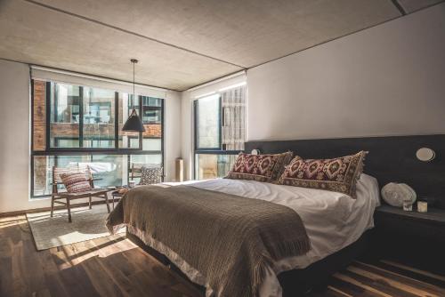 una camera con letto e una camera con finestre di Be House Suites & Spa a Punta del Este