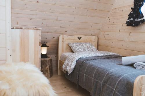 sypialnia z łóżkiem w drewnianym domku w obiekcie Chata Tatritis w mieście Kościelisko