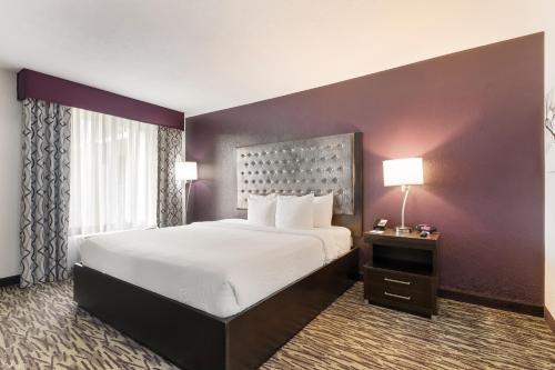 a hotel room with a large bed and two lamps at Clarion Inn & Suites Across From Universal Orlando Resort in Orlando