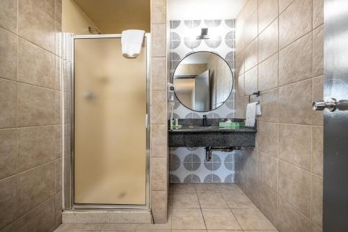 La Luna Inn, Ascend Hotel Collection في سان فرانسيسكو: حمام مع دش مع مرآة ومغسلة