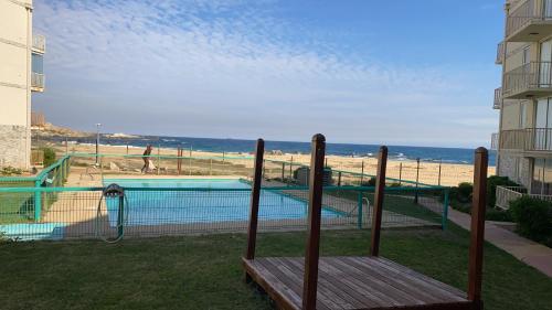 uitzicht op een zwembad en het strand bij A pasos del mar Lugar ideal para descansar in El Tabo