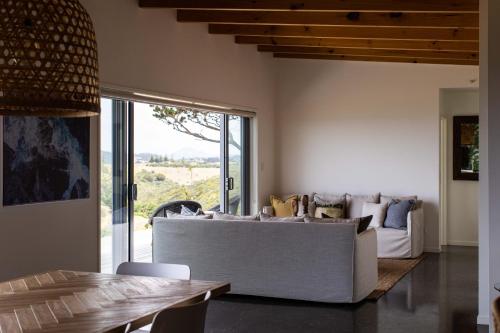 a living room with a couch and a table at Oceanview Cottage Tutukaka Coast in Tutukaka