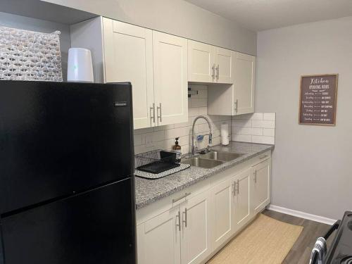 a kitchen with a black refrigerator and a sink at The Delores - 2 Bedroom Apt in Quilt Town, USA in Hamilton
