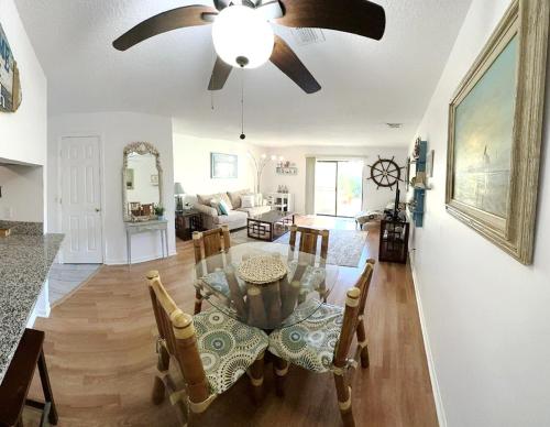 a living room with a dining table and a ceiling fan at The Ultimate Beach Getaway in Cape Canaveral