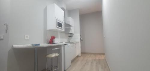 a small kitchen with white cabinets and a counter at Apartamentos Las trece llaves Jacuzzi bajo reserva in Merida