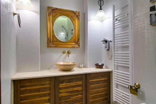 La salle de bains est pourvue d'un lavabo et d'un miroir. dans l'établissement Hotel Kassaros, à Metsovo