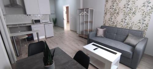 a living room with a couch and a table at Apartamentos Las trece llaves Jacuzzi bajo reserva in Merida