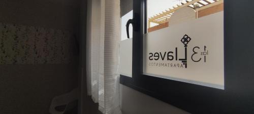 a window in a room with a sign on the wall at Apartamentos Las trece llaves Jacuzzi bajo reserva in Merida