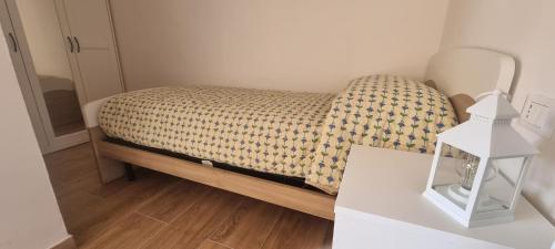 a small bed in a room with a white table at Appartamento in una valle di Luce in Pizzoferrato