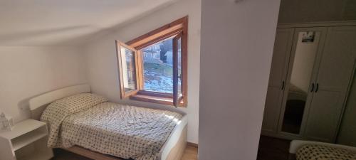 Habitación pequeña con cama y ventana en Appartamento in una valle di Luce en Pizzoferrato