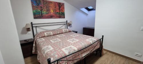 a bedroom with a bed and a painting on the wall at Appartamento in una valle di Luce in Pizzoferrato