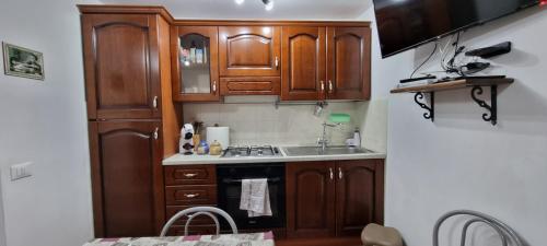 a kitchen with wooden cabinets and a stove top oven at Appartamento in una valle di Luce in Pizzoferrato