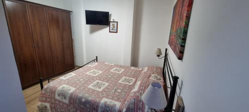 a bedroom with a bed and a wooden cabinet at Appartamento in una valle di Luce in Pizzoferrato