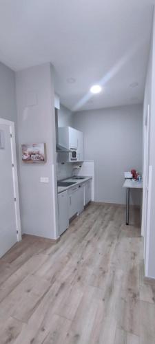 a kitchen with white appliances and a wooden floor at Apartamentos Las trece llaves Jacuzzi bajo reserva in Merida