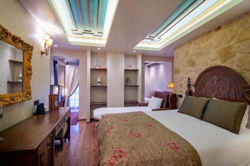 a hotel room with a large bed and a mirror at Hotel Kassaros in Metsovo