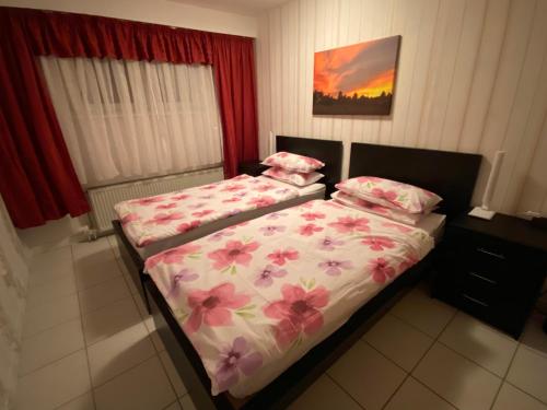 1 Schlafzimmer mit 2 Betten mit rosa Blumen in der Unterkunft Suite Elisabeth in Wetzlar