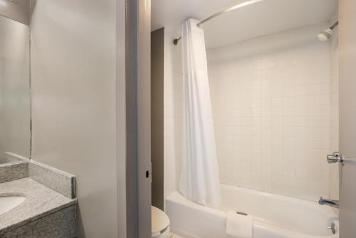 een badkamer met een bad, een toilet en een wastafel bij RED CARPET INN EDISON in Edison