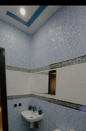 a blue and white bathroom with a sink at Appartement Haut Standing Petit Déjeuner INCLUS in Tangier